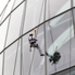 The first torchbearer of the day, Richard Jackson, abseils down the Sage building in Gateshead. Picture: LOCOG