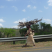 Swasi woman carrying her baby and sticks above her head to build a fire.
