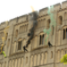 Giles Long MBE holds the Olympic Flame as abseilers descend down the side of Norwich Castle trailing coloured smoke at the beginning of Day 48.