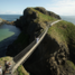 Torchbearer Denis Broderick holds the Olympic Flame on the Carrick-a-Rede rope bridge during Day 17 of the London 2012 Olympic Torch Relay. Picture: LOCOG